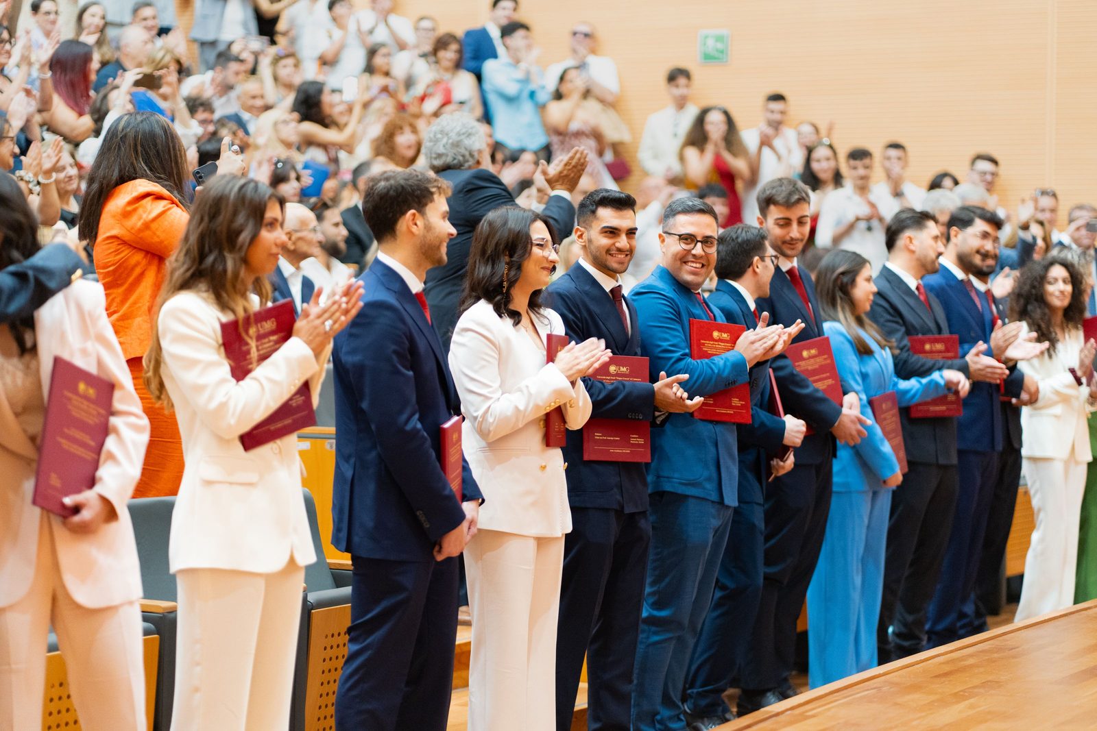 Cerimônia de diplomação com formandos e plateia cheia